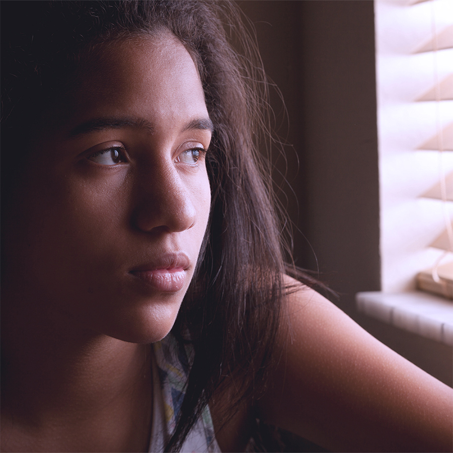 sad girl looking out a window